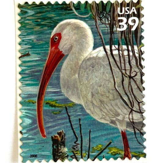 Vintage White Ibis postage stamp from the 2006 Southern Florida Wetland issue in the Nature of America series featuring a white ibis with a coral-red bill standing in blue-green wetland water on unused 39-cent USPS postage, Scott 4099j.