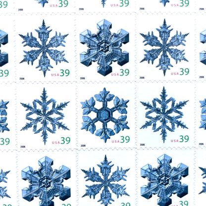 Image of four 39-cent “Holiday Snowflakes” USPS postage stamps featuring blue snowflakes on a white background from the 2006 Contemporary Christmas Series (Scott #4101, Scott #4102, Scott #4103, Scott #4104)