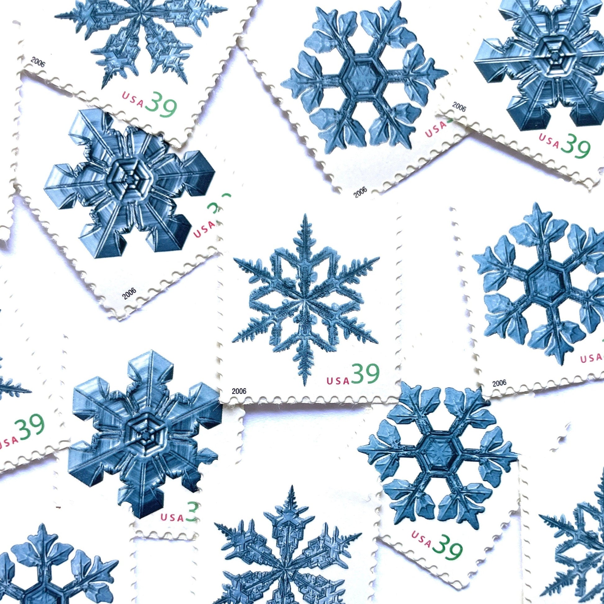 Image of four 39-cent “Holiday Snowflakes” USPS postage stamps featuring blue snowflakes on a white background from the 2006 Contemporary Christmas Series (Scott #4101, Scott #4102, Scott #4103, Scott #4104)
