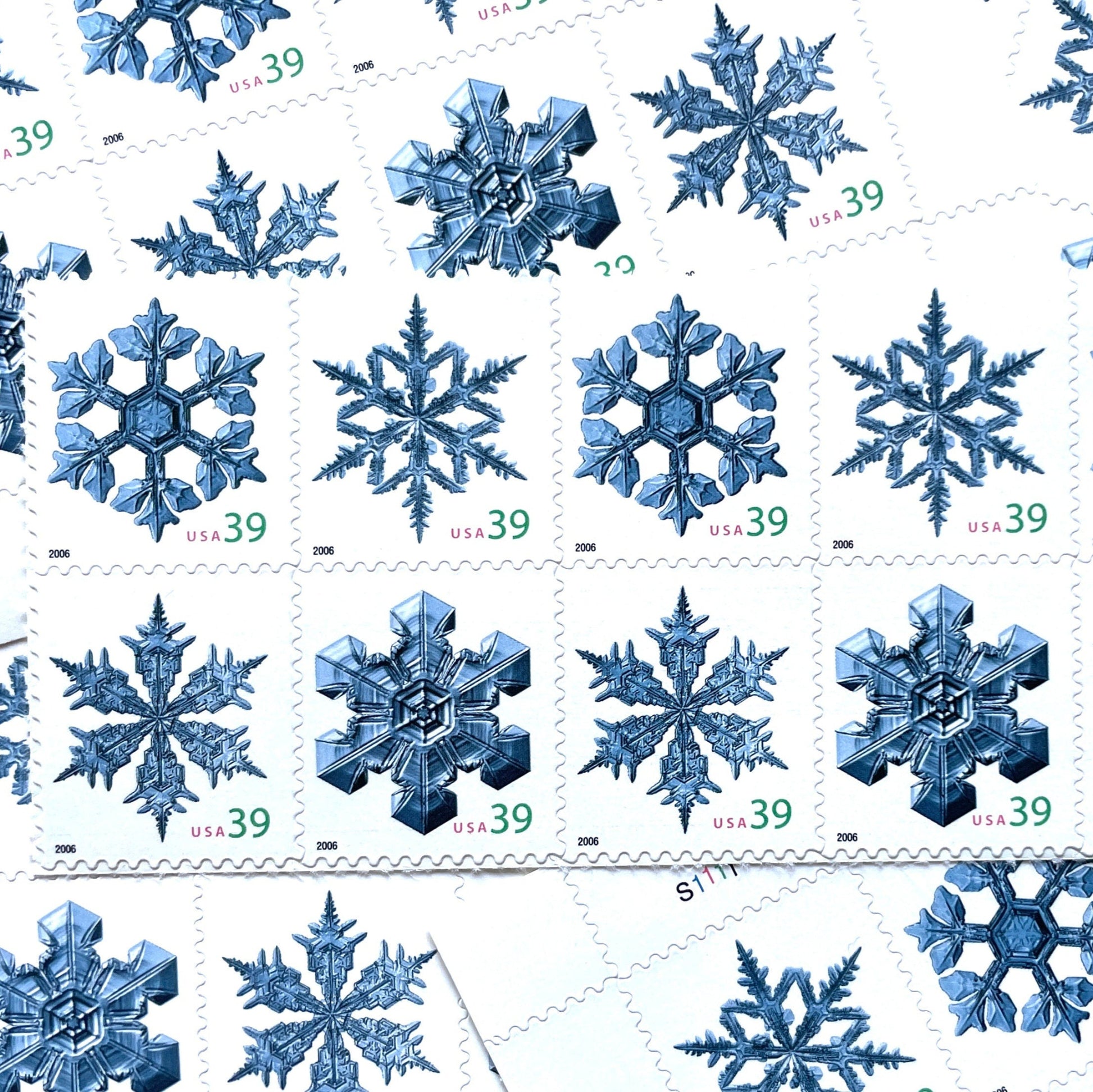 Image of four 39-cent “Holiday Snowflakes” USPS postage stamps featuring blue snowflakes on a white background from the 2006 Contemporary Christmas Series (Scott #4101, Scott #4102, Scott #4103, Scott #4104)