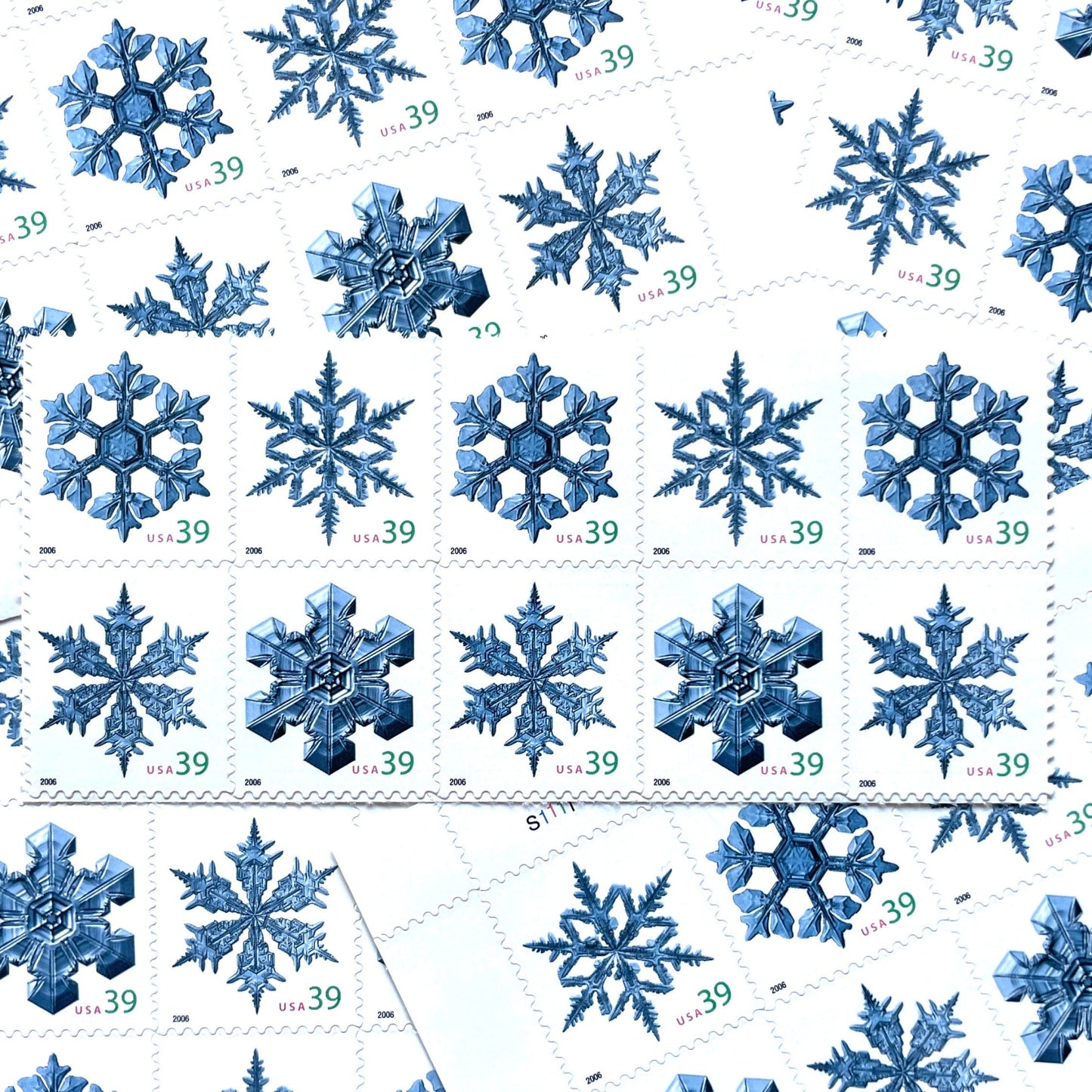Image of four 39-cent “Holiday Snowflakes” USPS postage stamps featuring blue snowflakes on a white background from the 2006 Contemporary Christmas Series (Scott #4101, Scott #4102, Scott #4103, Scott #4104)