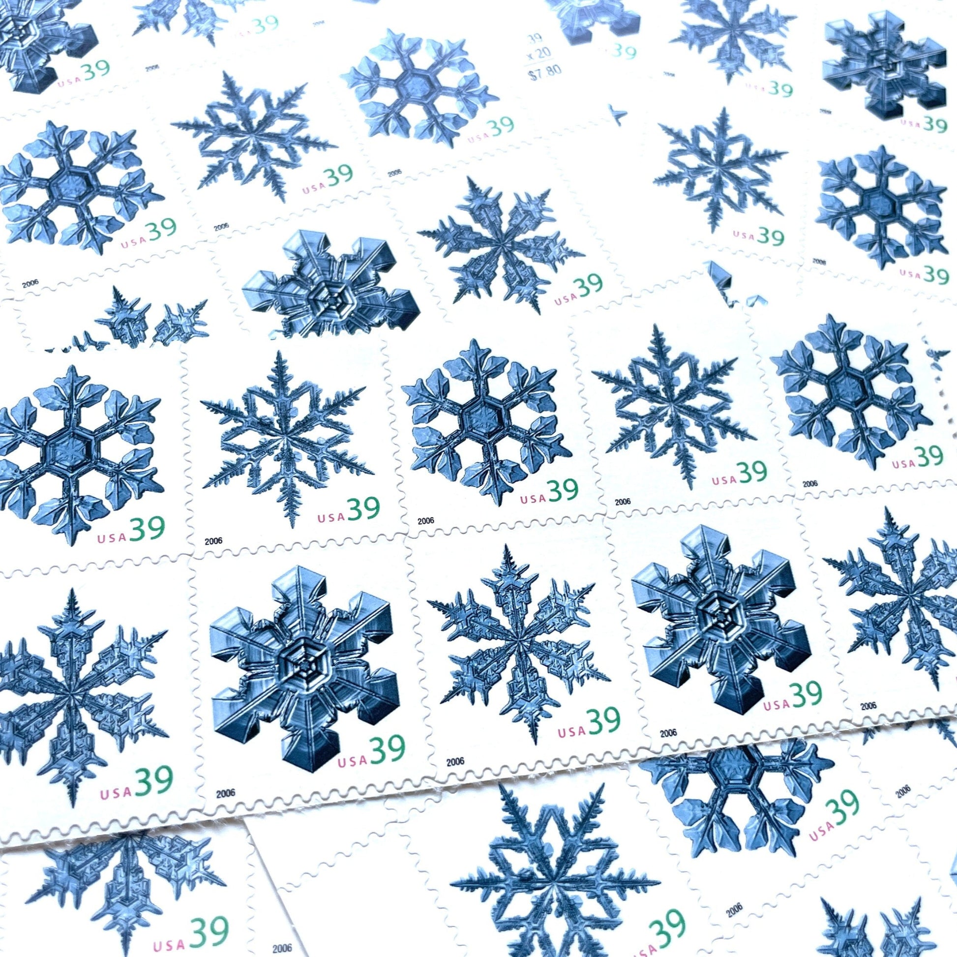 Image of four 39-cent “Holiday Snowflakes” USPS postage stamps featuring blue snowflakes on a white background from the 2006 Contemporary Christmas Series (Scott #4101, Scott #4102, Scott #4103, Scott #4104)