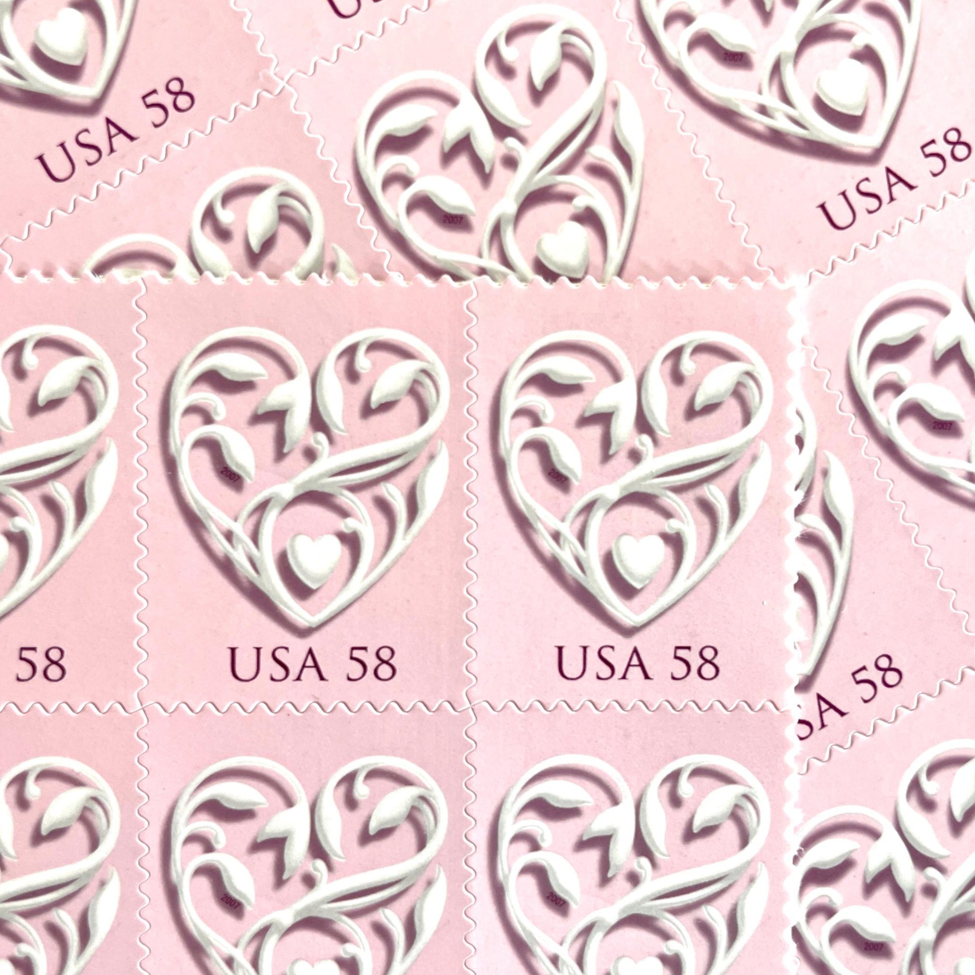 Image of 2007 Wedding Series “Pink Wedding Hearts” unused 58-cent USPS mail stamps. Scott #4152. Stamp Themes: Heart, Love, Wedding, Bridal. Pink, White, Multicolored postage stamp. Perfect postage stamp to use for save the date announcements, wedding invitation postage, shower invitations, thank you cards, valentine’s day, and snail mail.