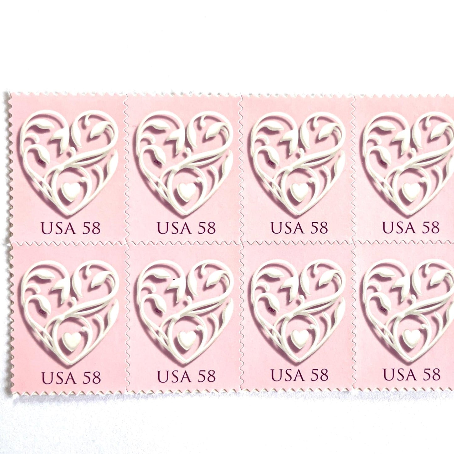 Image of 2007 Wedding Series “Pink Wedding Hearts” unused 58-cent USPS mail stamps. Scott #4152. Stamp Themes: Heart, Love, Wedding, Bridal. Pink, White, Multicolored postage stamp. Perfect postage stamp to use for save the date announcements, wedding invitation postage, shower invitations, thank you cards, valentine’s day, and snail mail.