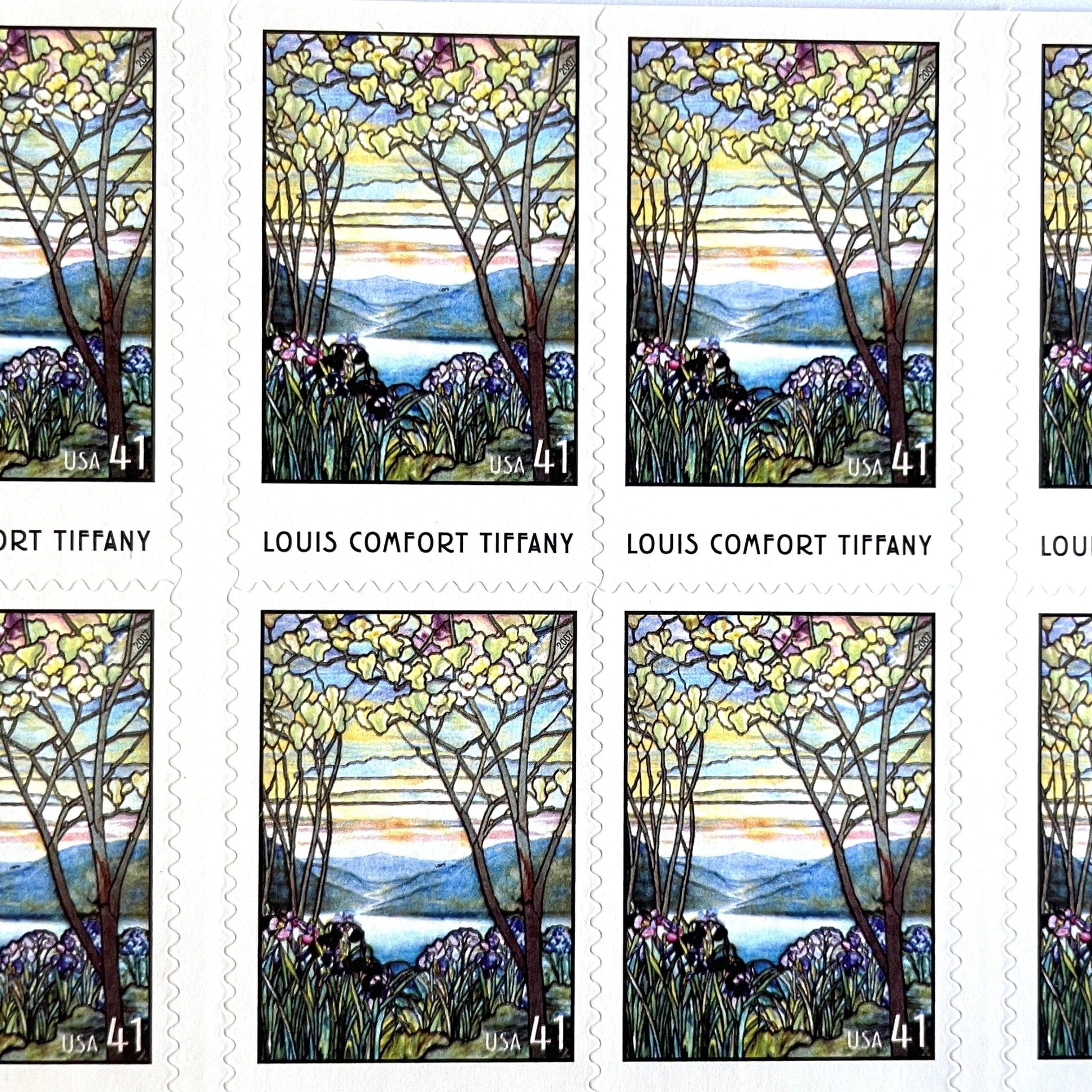 Image of 2007 American Treasures series “Louis Comfort Tiffany” (Magnolias and Irises in Stained Glass) unused 41-cent vintage USPS mail stamps. Scott #4165. Stamp Themes: Flowers, Floral, Botanical, Gardening, Nature, Tiffany Stained Glass. Purple, Blue, White, Multicolored self-adhesive postage stamp. Perfect postage stamp to use for save the date announcements, wedding invitation postage, bridal shower invitations, birth announcements, thank you cards, valentine’s day, and snail mail.