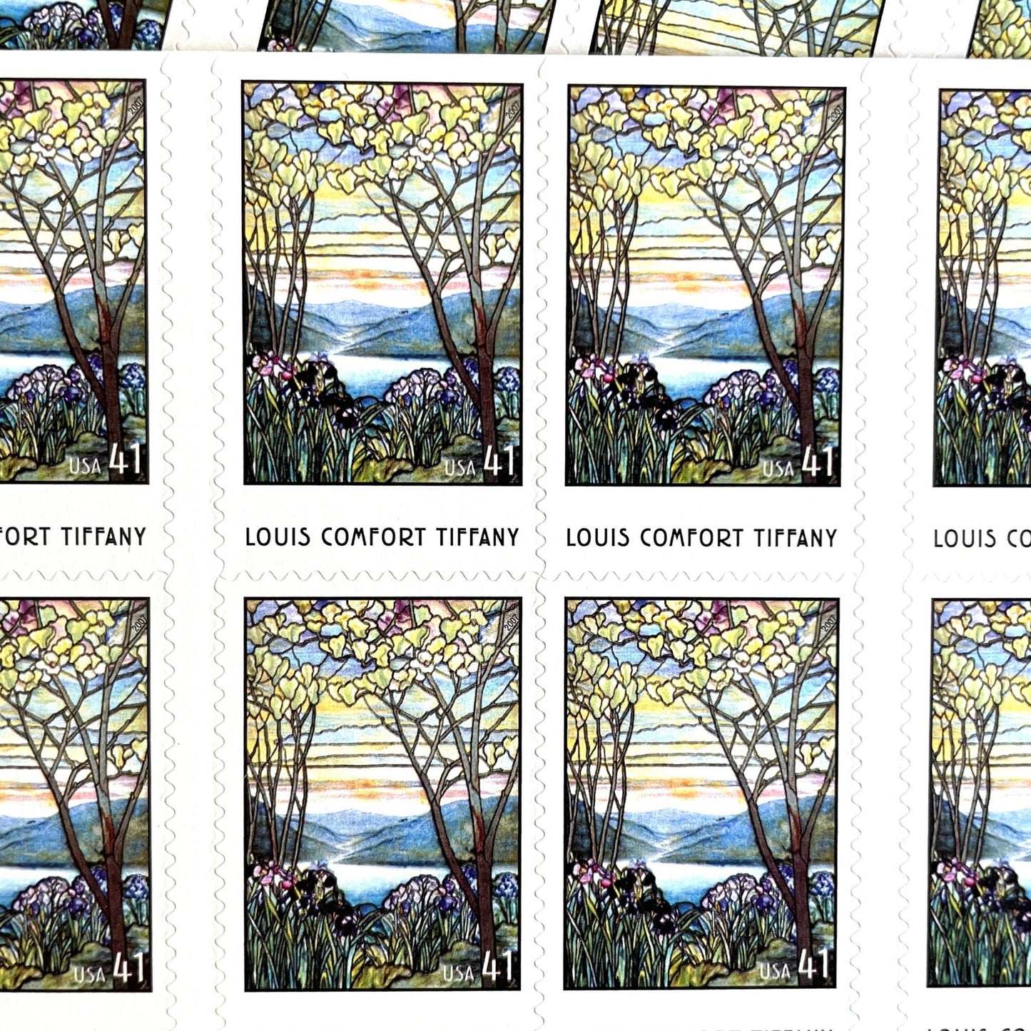 Image of 2007 American Treasures series “Louis Comfort Tiffany” (Magnolias and Irises in Stained Glass) unused 41-cent vintage USPS mail stamps. Scott #4165. Stamp Themes: Flowers, Floral, Botanical, Gardening, Nature, Tiffany Stained Glass. Purple, Blue, White, Multicolored self-adhesive postage stamp. Perfect postage stamp to use for save the date announcements, wedding invitation postage, bridal shower invitations, birth announcements, thank you cards, valentine’s day, and snail mail.