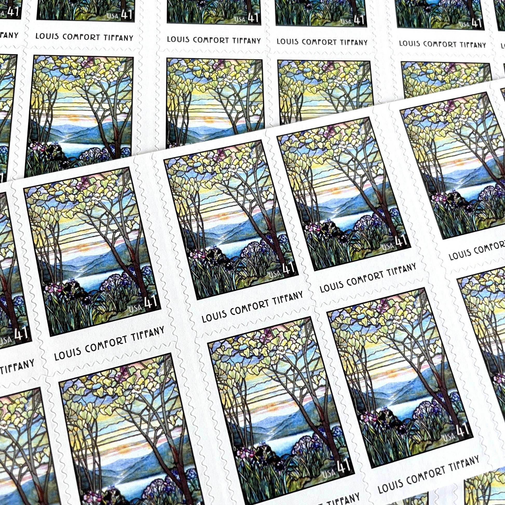 Image of 2007 American Treasures series “Louis Comfort Tiffany” (Magnolias and Irises in Stained Glass) unused 41-cent vintage USPS mail stamps. Scott #4165. Stamp Themes: Flowers, Floral, Botanical, Gardening, Nature, Tiffany Stained Glass. Purple, Blue, White, Multicolored self-adhesive postage stamp. Perfect postage stamp to use for save the date announcements, wedding invitation postage, bridal shower invitations, birth announcements, thank you cards, valentine’s day, and snail mail.
