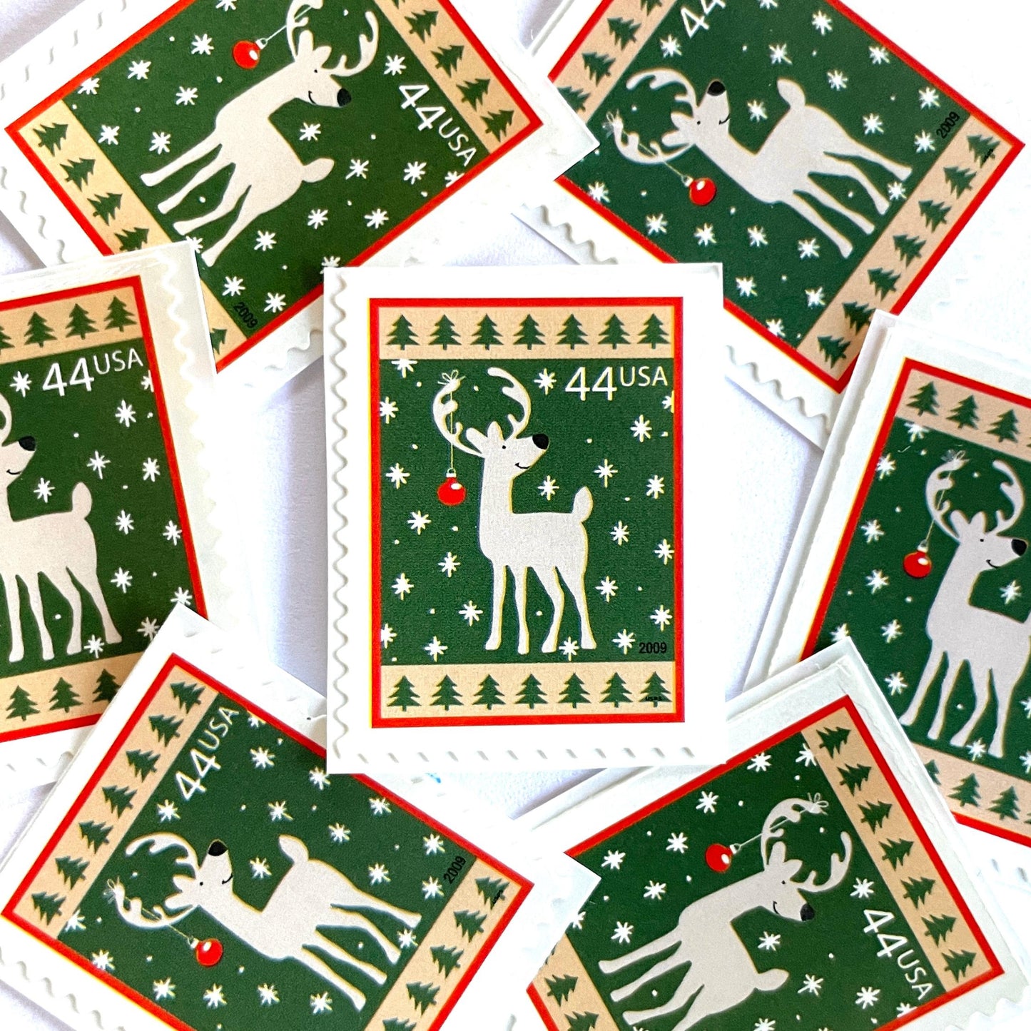 Image of 44-cent Contemporary Christmas Winter Holidays Reindeer USPS postage stamp featuring a reindeer on green and white background with a design reminiscent of Christmas wrapping paper. Scott #4425. Stamp themes: Christmas, holidays, winter, reindeer, deer, stag, reindeer, winter wedding, winter save-the-date. Green postage stamp.