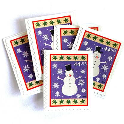 Image of 44-cent Contemporary Christmas Winter Holidays Snowman USPS postage stamp featuring a white snowman and snowflakes against a purple background with a design reminiscent of Christmas wrapping paper. Scott #4426. Stamp themes: Christmas, holidays, winter, snow, snowflakes, winter wedding, winter save-the-date. Purple postage stamp.