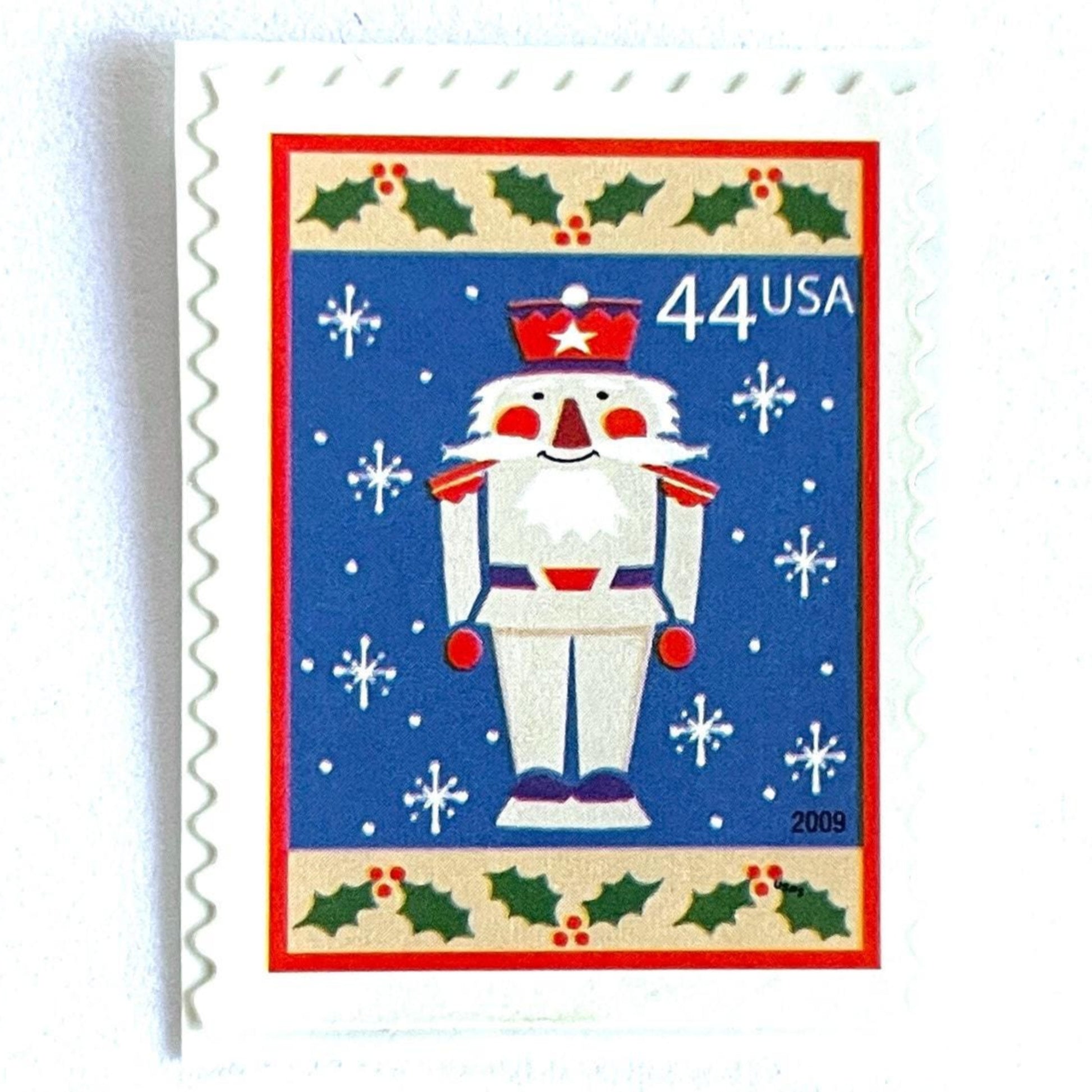 Image of 44-cent Contemporary Christmas Winter Holidays Toy Soldier USPS postage stamp featuring a smiling toy soldier standing at attention, set against a blue background with white snowflakes falling, evoking the imagery of classic holiday stories like “The Nutcracker,” with a design reminiscent of Christmas wrapping paper. Scott #4428. Stamp themes: Christmas, holidays, winter, snowflakes, toys, wooden toys, nutcracker, German, winter wedding, winter save-the-date. Blue postage stamp.