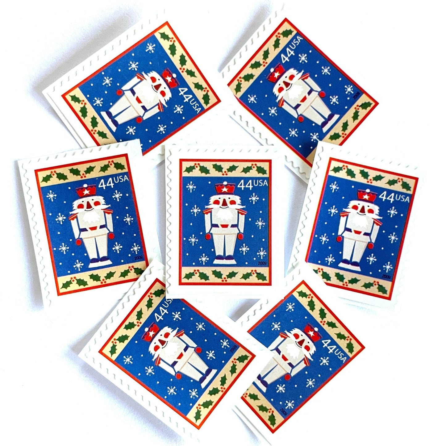 Image of 44-cent Contemporary Christmas Winter Holidays Toy Soldier USPS postage stamps featuring a smiling toy soldier standing at attention, set against a blue background with white snowflakes falling, evoking the imagery of classic holiday stories like “The Nutcracker,” with a design reminiscent of Christmas wrapping paper. Scott #4428. Stamp themes: Christmas, holidays, winter, snowflakes, toys, wooden toys, nutcracker, German, winter wedding, winter save-the-date. Blue postage stamp.