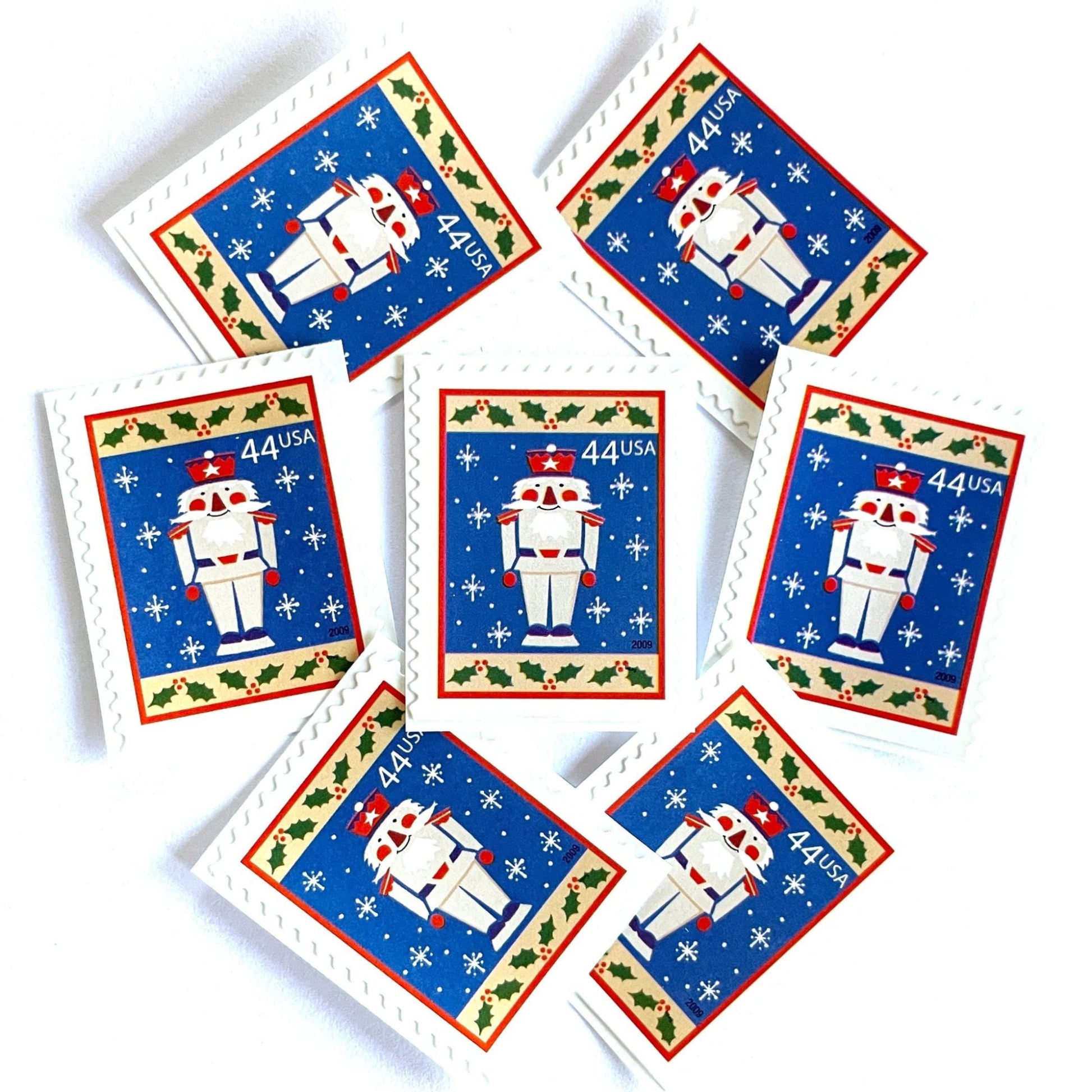 Image of 44-cent Contemporary Christmas Winter Holidays Toy Soldier USPS postage stamps featuring a smiling toy soldier standing at attention, set against a blue background with white snowflakes falling, evoking the imagery of classic holiday stories like “The Nutcracker,” with a design reminiscent of Christmas wrapping paper. Scott #4428. Stamp themes: Christmas, holidays, winter, snowflakes, toys, wooden toys, nutcracker, German, winter wedding, winter save-the-date. Blue postage stamp.