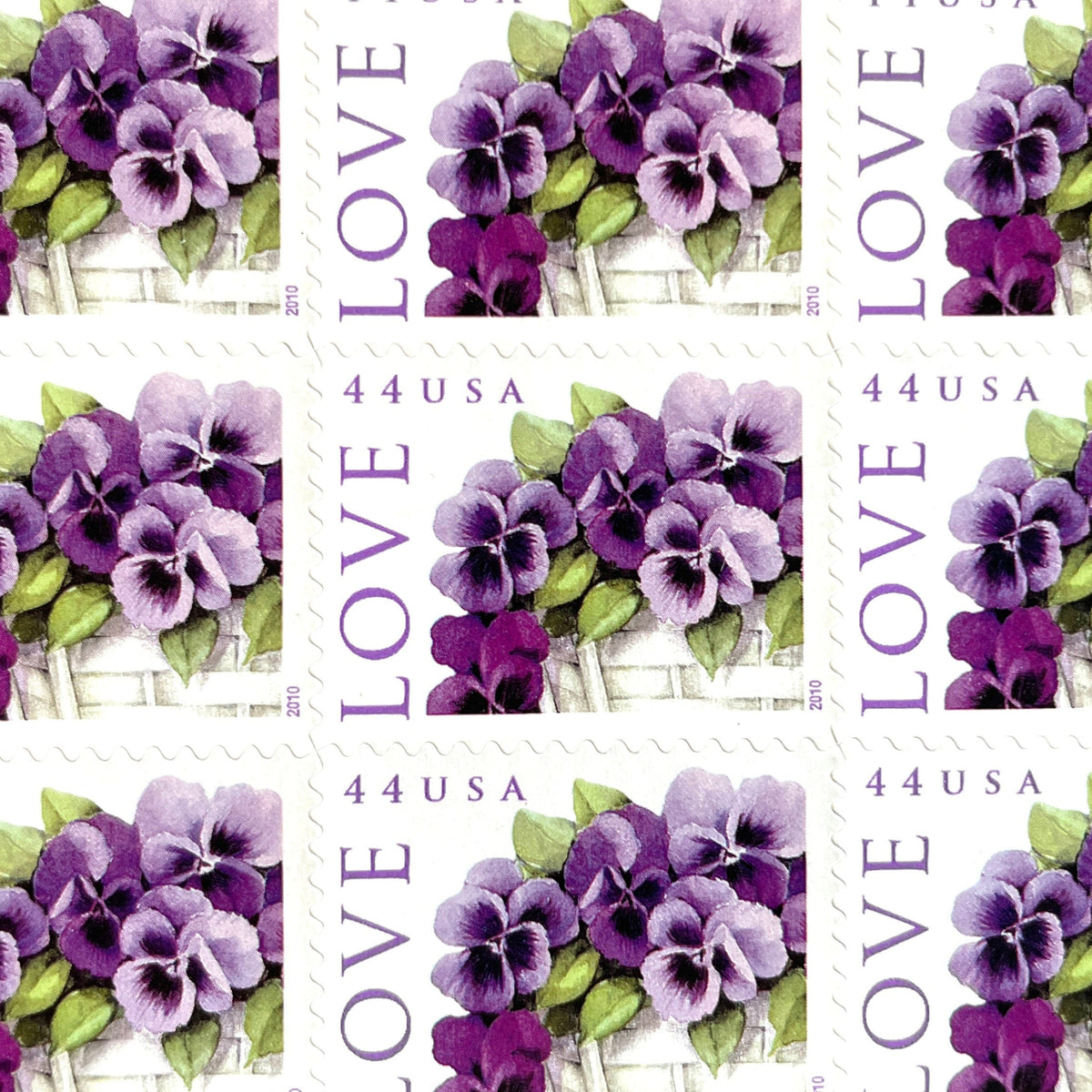 Pansies in a Basket postage stamps from 2010 featuring purple pansies and green foliage in a white woven cart on vintage unused 44-cent USPS postage, Scott 4450.