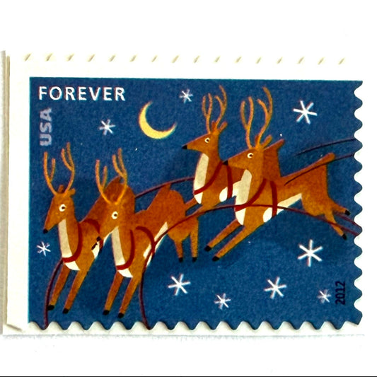 Reindeer in Flight and Moon postage stamp from 2012 featuring flying Christmas reindeer beside a glowing moon in a wintry night sky on unused USPS Forever postage, Scott 4712.