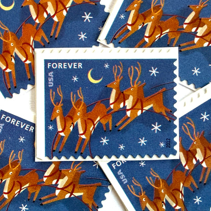 Reindeer in Flight and Moon postage stamps from 2012 featuring flying Christmas reindeer beside a glowing moon in a wintry night sky on unused USPS Forever postage, Scott 4712.