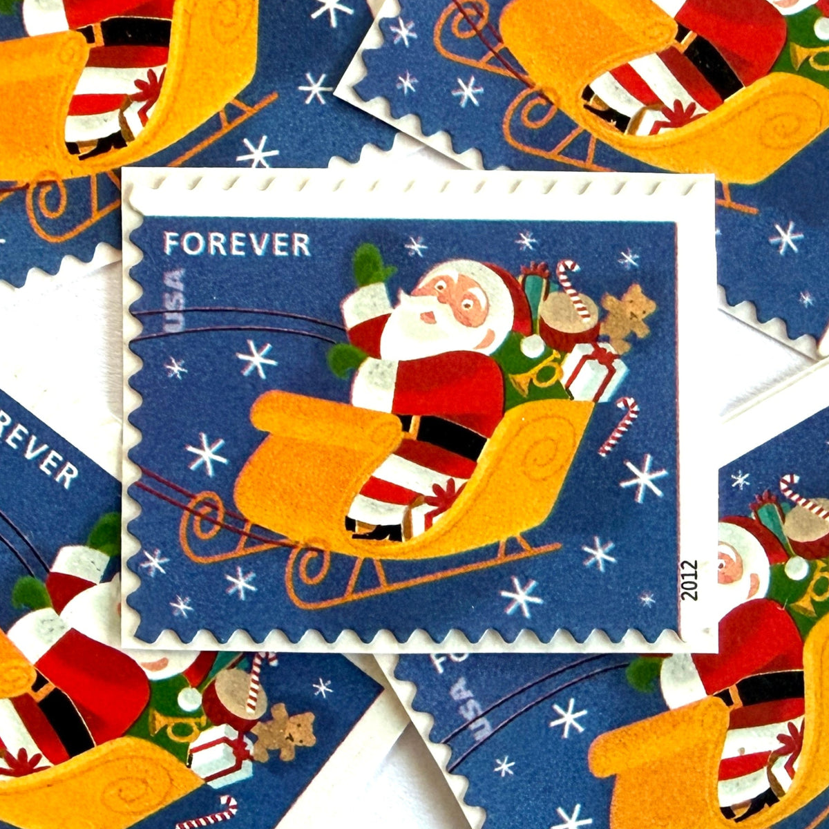 Santa Flying in Sleigh postage stamps from 2012 featuring St. Nick traveling through a wintry Christmas Eve sky in his sleigh on unused USPS Forever postage, Scott 4713.