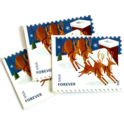 Reindeer Over Roof postage stamps from 2012 featuring flying Christmas reindeer above snow-covered rooftops in a wintry night scene on unused USPS Forever postage, Scott 4714.