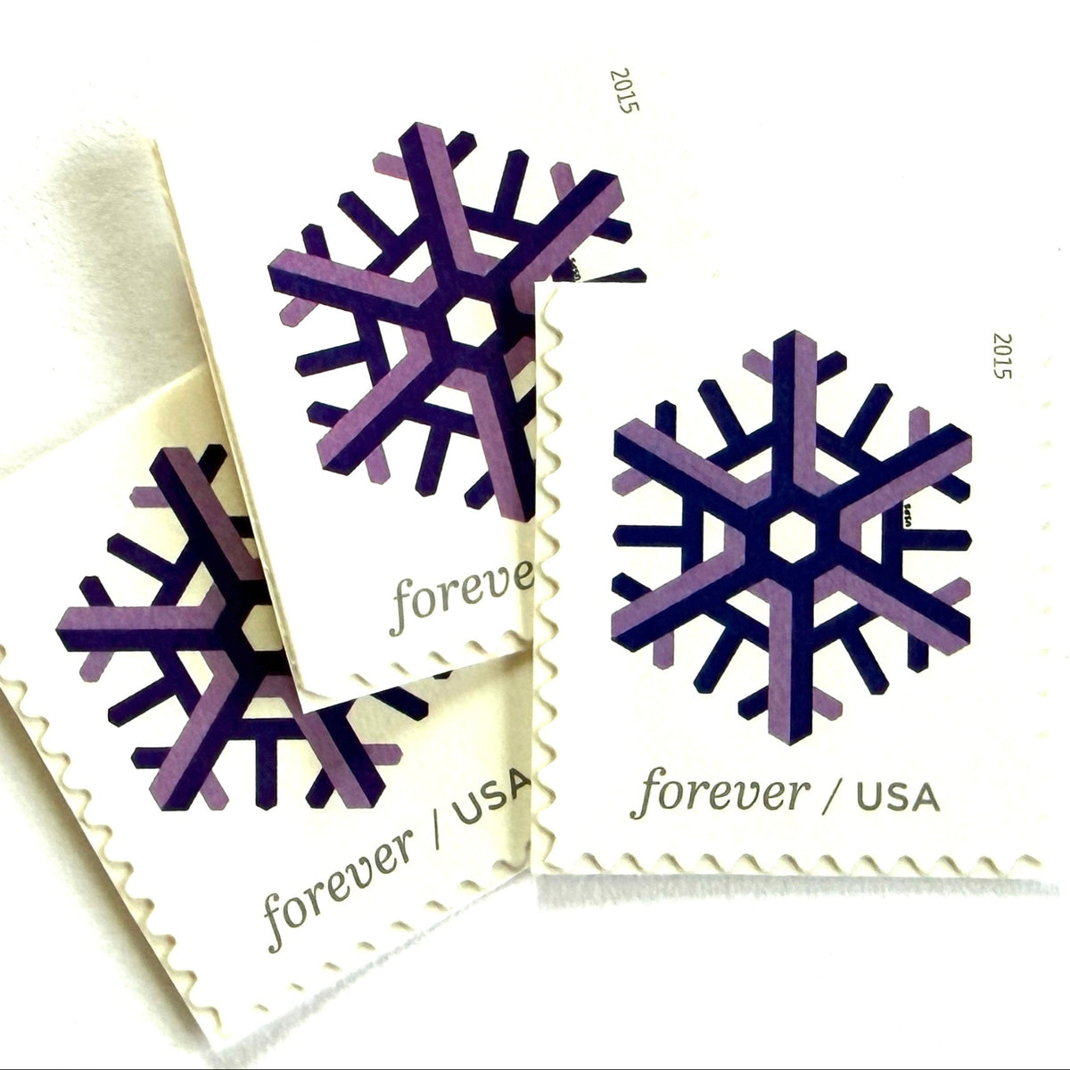 Purple and lilac Geometric Snowflake postage stamps from 2015 featuring a stylized crystalline winter design on unused USPS Forever postage, Scott 5031.