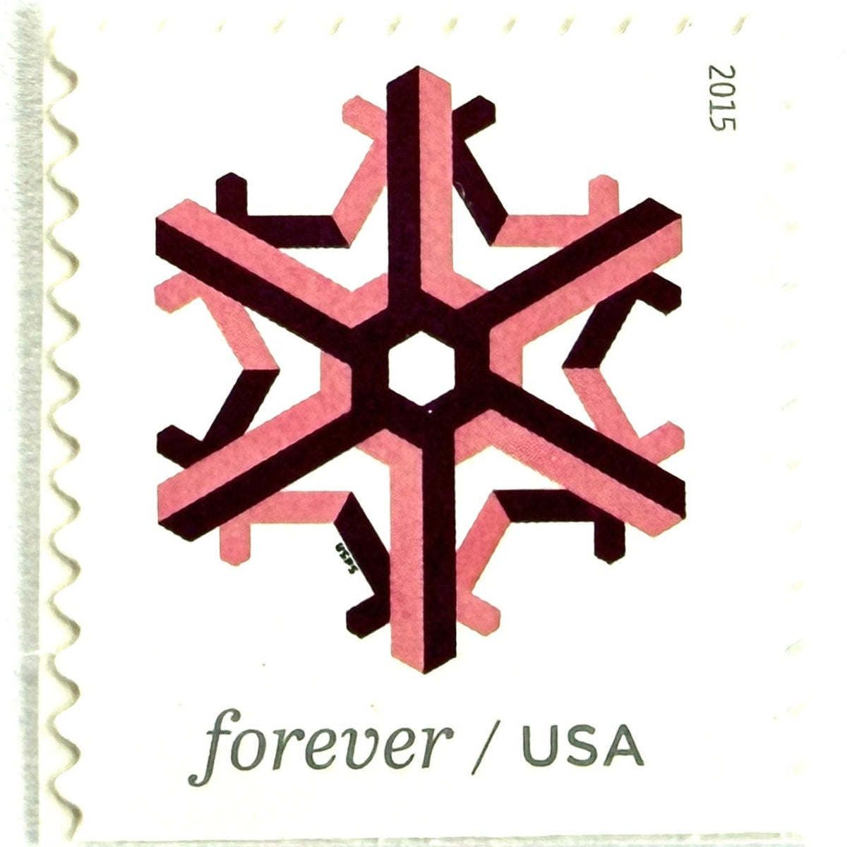 Pink and dark red Geometric Snowflake postage stamp from 2015 featuring a stylized crystalline winter design on unused USPS Forever postage, Scott 5034.