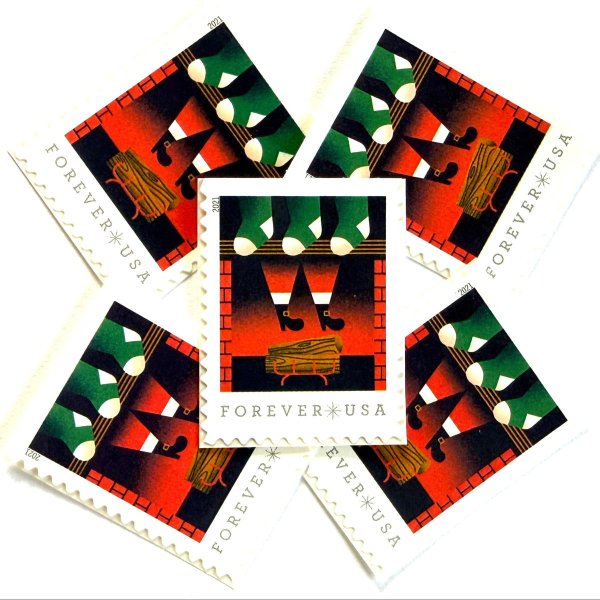 Santa Descending Chimney postage stamps from 2021 featuring St. Nick’s black-booted legs above a red-brick fireplace with green stockings on unused USPS Forever postage, Scott 5645.