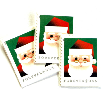 Head of Santa Claus postage stamps from 2021 featuring a close-up of a smiling, winking St. Nick against a green background on unused USPS Forever postage, Scott 5646.