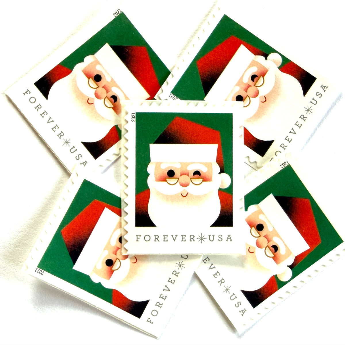 Head of Santa Claus postage stamps from 2021 featuring a close-up of a smiling, winking St. Nick against a green background on unused USPS Forever postage, Scott 5646.
