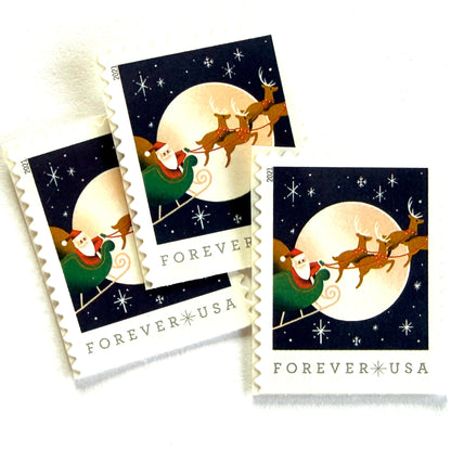 Santa Claus, Sleigh, and Reindeer in Flight postage stamps from 2021 featuring St. Nick and four reindeer flying across a full moon in a dark star-filled sky on unused USPS Forever postage, Scott 5647.
