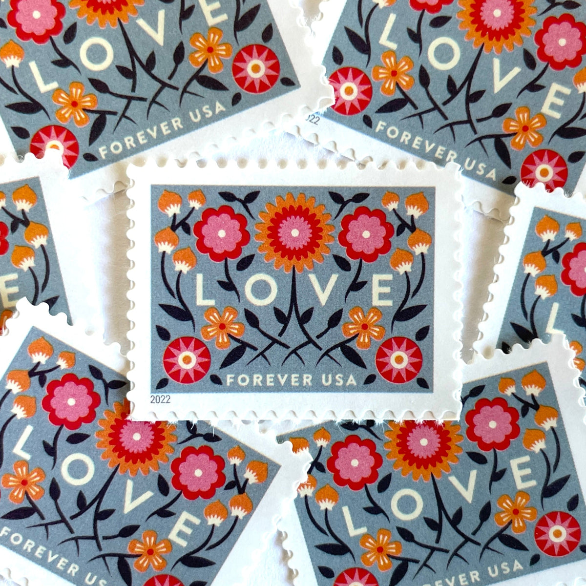 Love 2022 blue floral postage stamps featuring folk-art flowers, twisting vines, and abstract hearts on unused USPS Forever postage, Scott 5660.