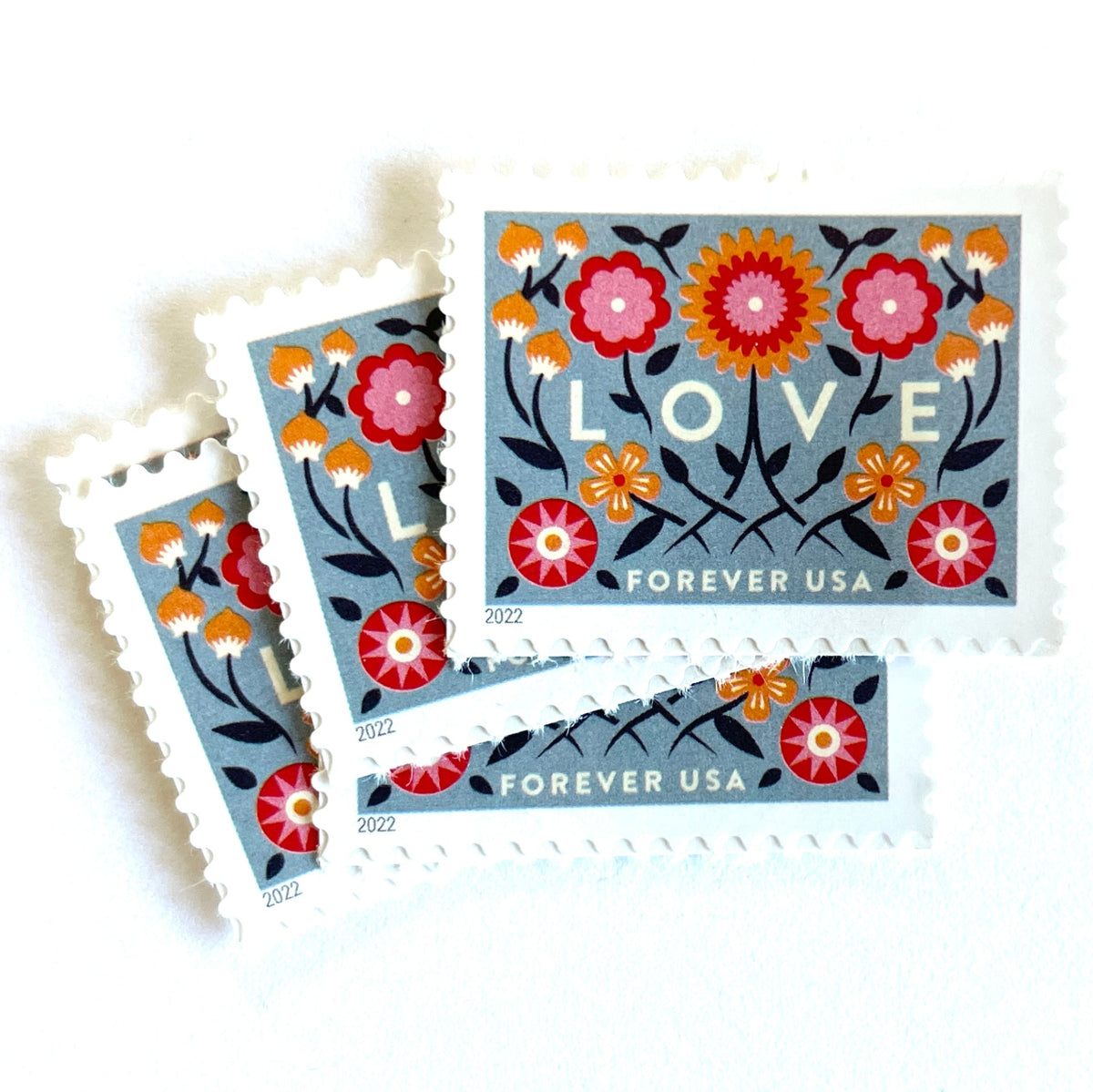 Love 2022 blue floral postage stamps featuring folk-art flowers, twisting vines, and abstract hearts on unused USPS Forever postage, Scott 5660.