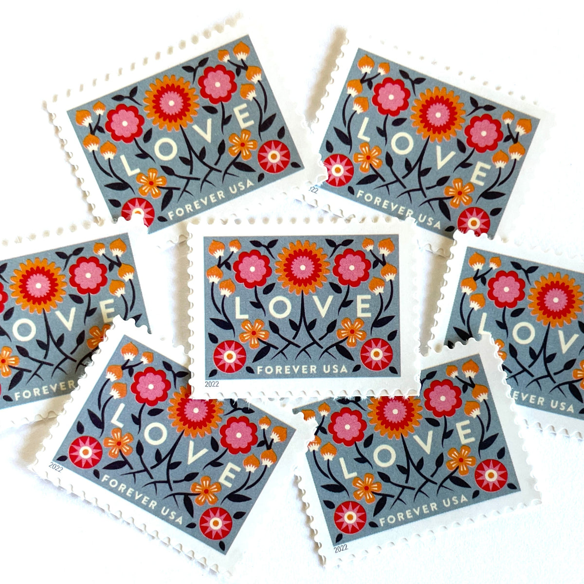 Love 2022 blue floral postage stamps featuring folk-art flowers, twisting vines, and abstract hearts on unused USPS Forever postage, Scott 5660.