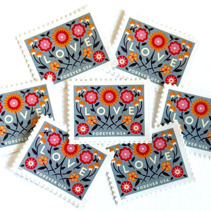 Love 2022 blue floral postage stamps featuring folk-art flowers, twisting vines, and abstract hearts on unused USPS Forever postage, Scott 5660.