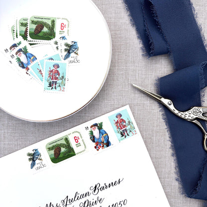 Unused Blue Christmas vintage postage stamp set perfect for adding a special touch to your holiday cards or letters! Each curated set is comprised of four (4) unused stamps with a total USPS postage value of $0.85 (USD) per set — enough postage to mail a standard letter weighing up to 1-ounce.