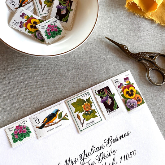 Vintage botanical postage stamp set featuring African Violet, Antillean Euphonia, Yellow Poplar, Rosebud Orchid, and Pansy unused U.S. postage stamps for wedding invitations and save-the-dates.