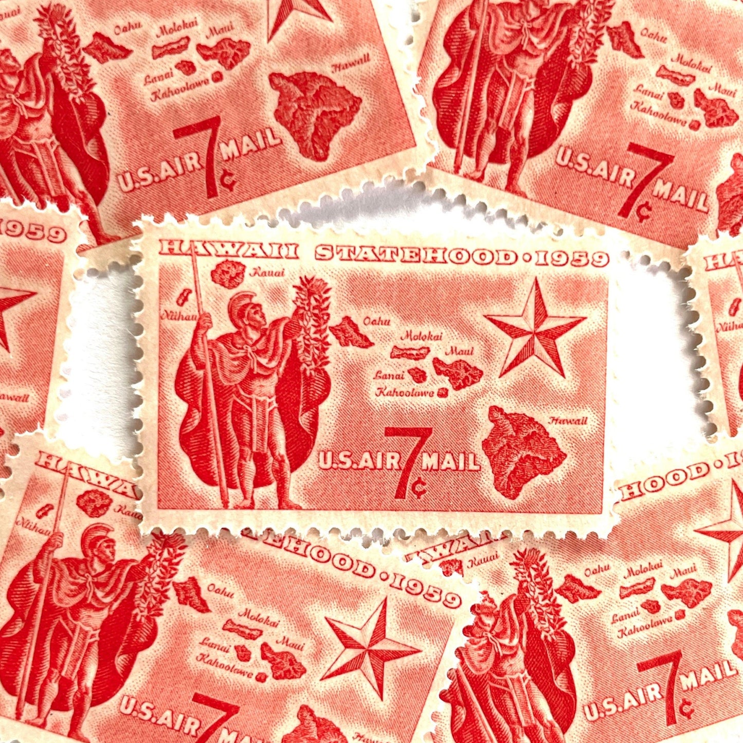 Image of Hawaii Statehood airmail postage stamps from 1959, featuring a Hawaiian Aliʻi extending a lei, a map of the Hawaiian Islands, and a star of statehood on vintage unused 7-cent USPS postage, Scott C55.