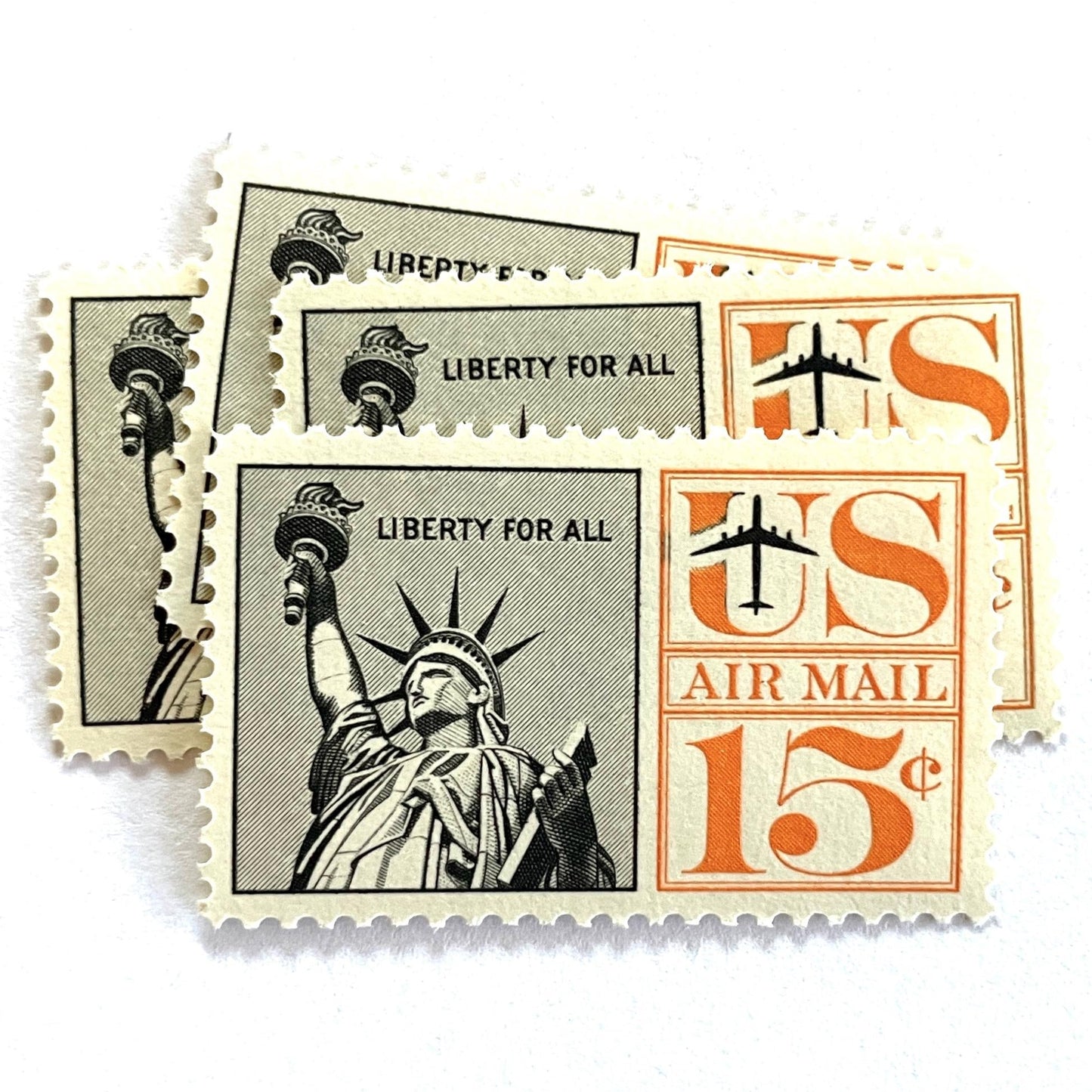 Image of 1959-1961 “Statue of Liberty” 15-cent air mail stamps. Scott #C58. Stamp Themes: Statue of Liberty, NYC, New York City, Big Apple, Air Mail. Black and orange postage stamp.