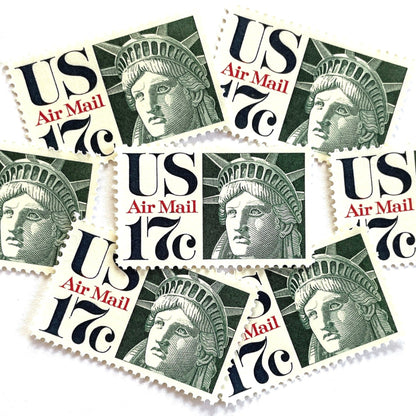 Image of 17-cent Airmail 1983 Liberty Crown USPS postage stamp featuring the Statue of Liberty. Scott #C80. Stamp themes: State of Liberty, Liberty Head, Lady Liberty, New York, NYC, Big Apple, Liberty Island, Immigrants, Immigration, Hope, Freedom, Refuge, Democracy, Crown, Torch, Tablet, Landmark, National Monument, United States of America. Green postage stamp.